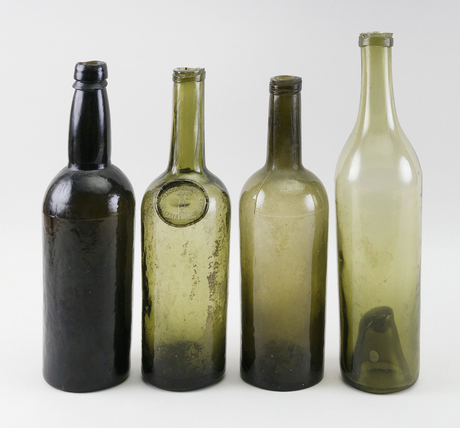 FOUR BLOWN-CAST GLASS BOTTLES 19th Century Heights from (1 of 4)