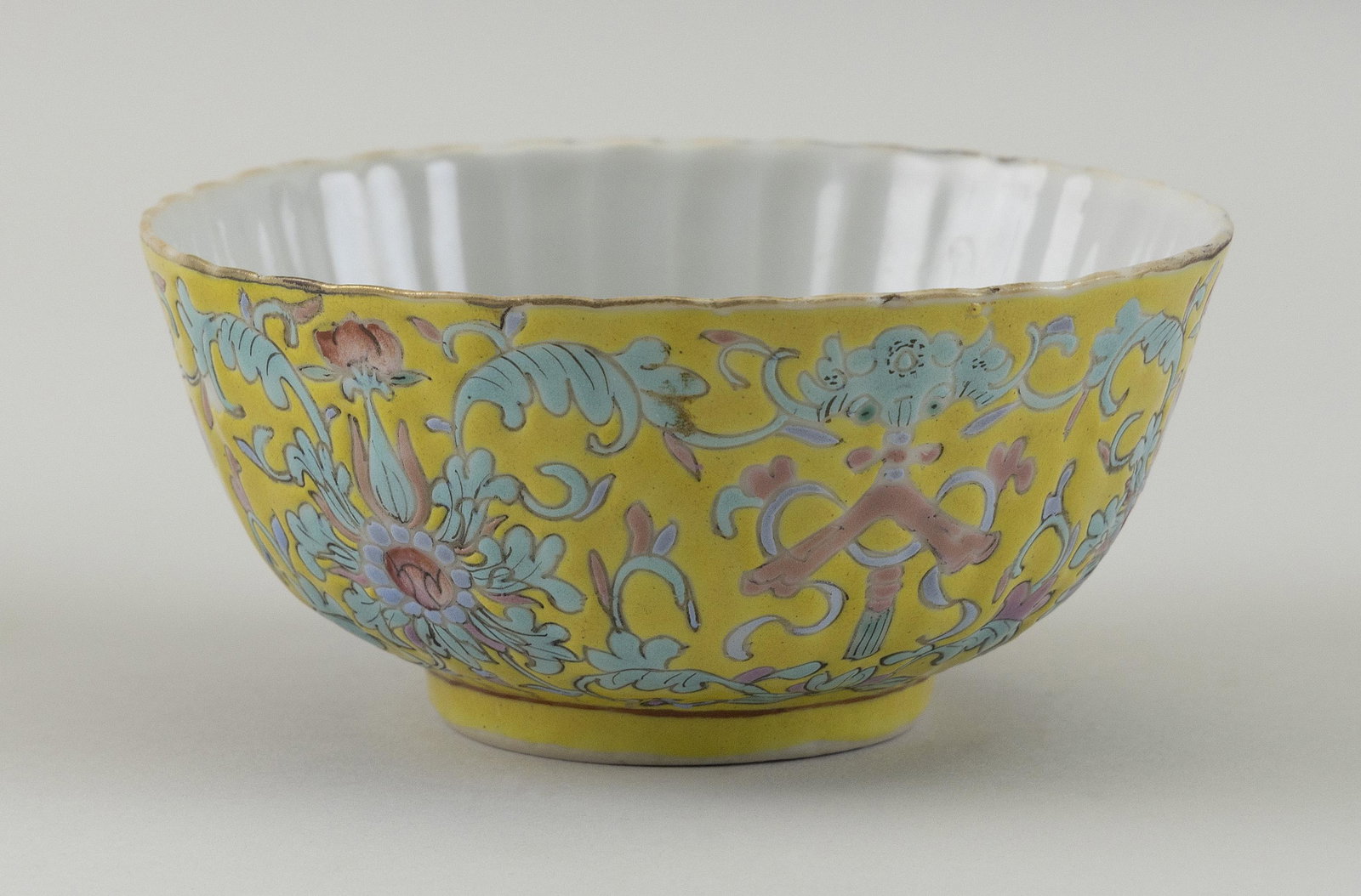 CHINESE FAMILLE JAUNE PORCELAIN BOWL 20th Century: CHINESE FAMILLE JAUNE PORCELAIN BOWL 20th Century Fluted interior. Exterior with scrolling lotus and bat decoration. Seal marked on base. Height 2.25”. Diameter 4.5”.