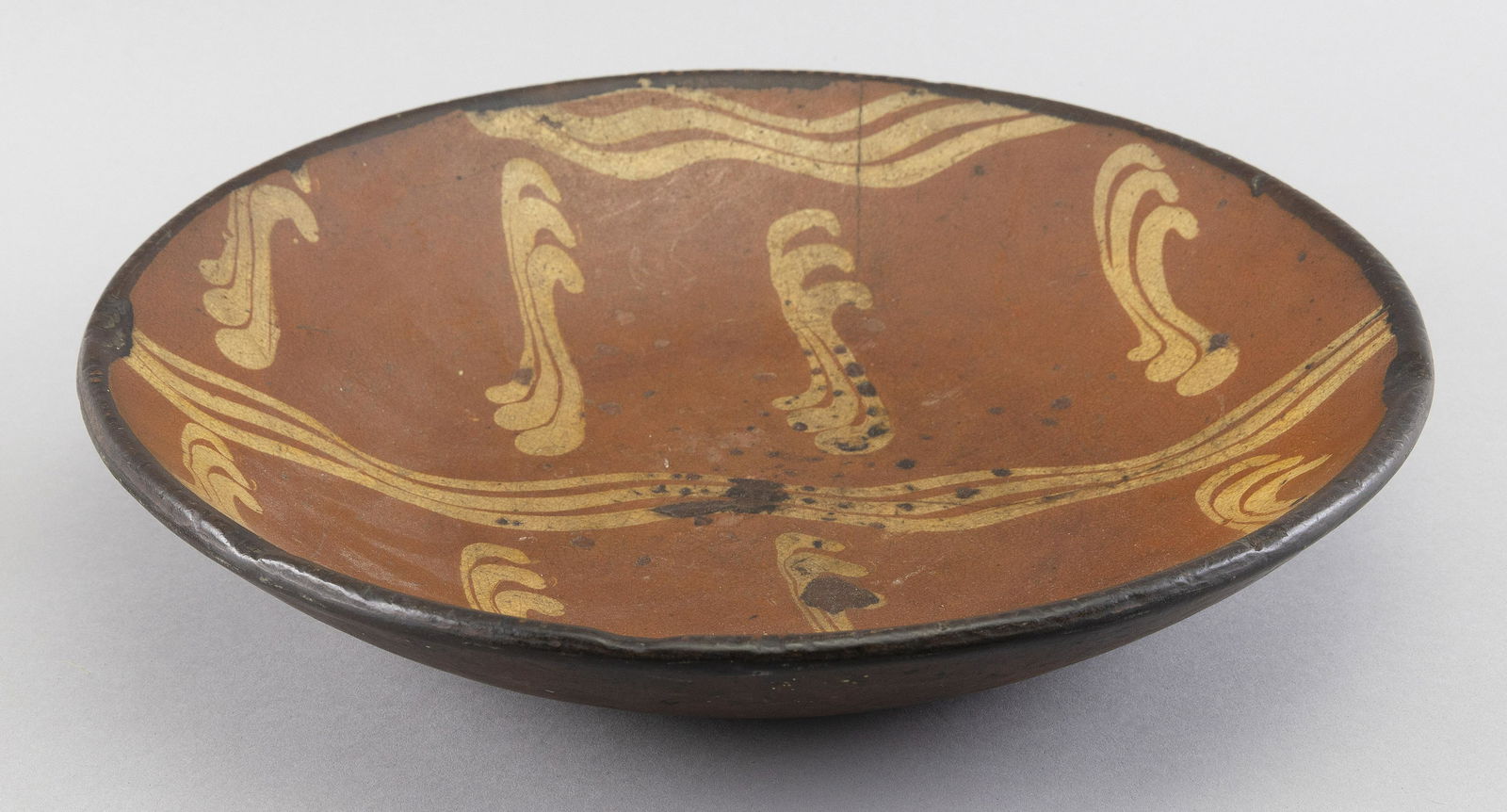 REDWARE POTTERY CHARGER 19th Century Diameter 13”.: REDWARE POTTERY CHARGER19th CenturySlip decoration.Diameter 13”.