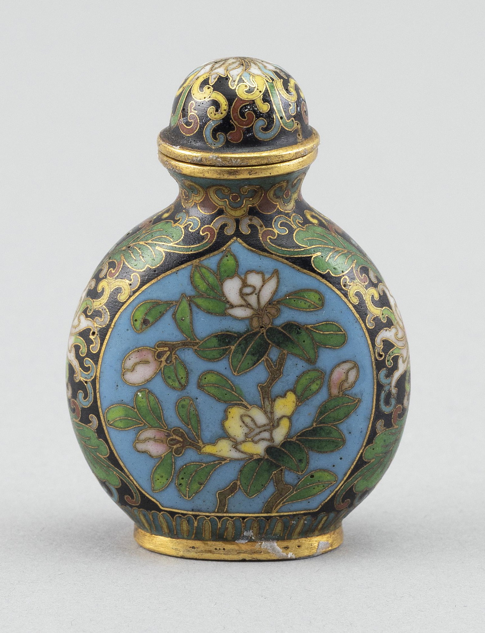 CHINESE CLOISONNÉ ENAMEL SNUFF BOTTLE 20th Century Height 2.25”.: CHINESE CLOISONNÉ ENAMEL SNUFF BOTTLE20th CenturyBoth faces with a central lotus cartouche against a black lotus and vine ground. Marked on base. Conforming stopper.Height 2.25”.
