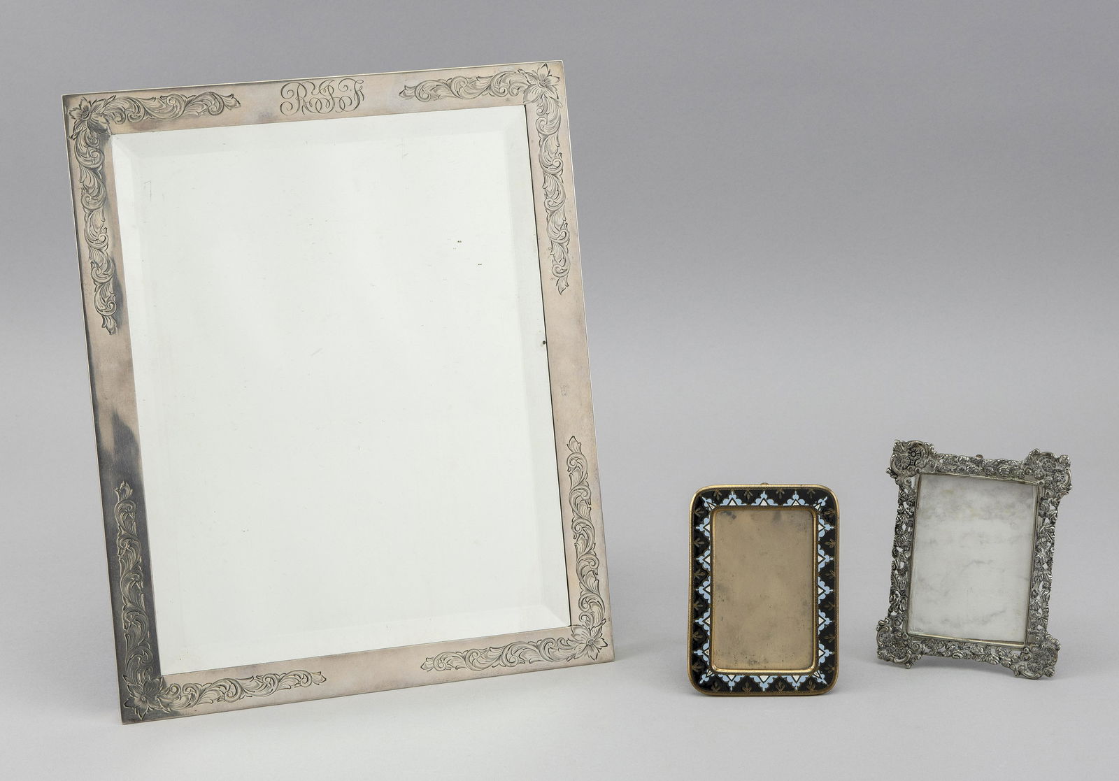 THREE TABLETOP PICTURE FRAMES 20th Century: THREE TABLETOP PICTURE FRAMES20th Century1) Engraved sterling silver with beveled glass. Monogrammed “RGJ”. Height 12.75”. Width 10.25”.2) Repoussé .800 silver. Height 4.7