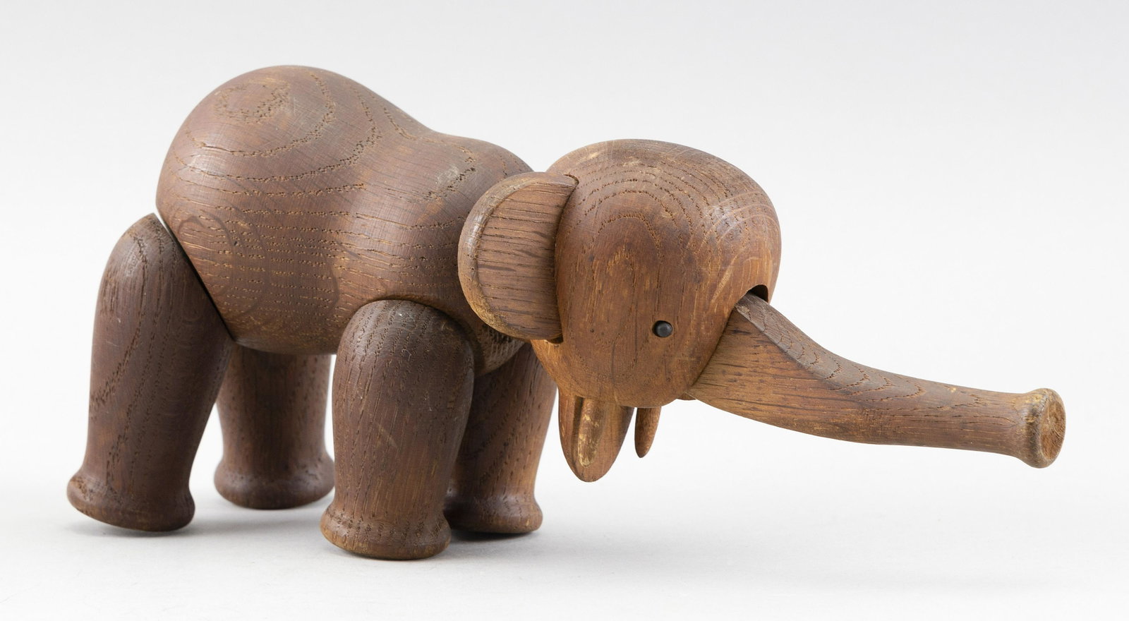 KAY BOJESEN ARTICULATED WOODEN ELEPHANT Mid-20th Century Height approx. 5”. Length 9.5”.: KAY BOJESEN ARTICULATED WOODEN ELEPHANT Mid-20th Century Movable trunk, head and legs. Marked on bottom of foot â€œDenmark”. Height approx. 5”. Length 9.5”. Width 4”.