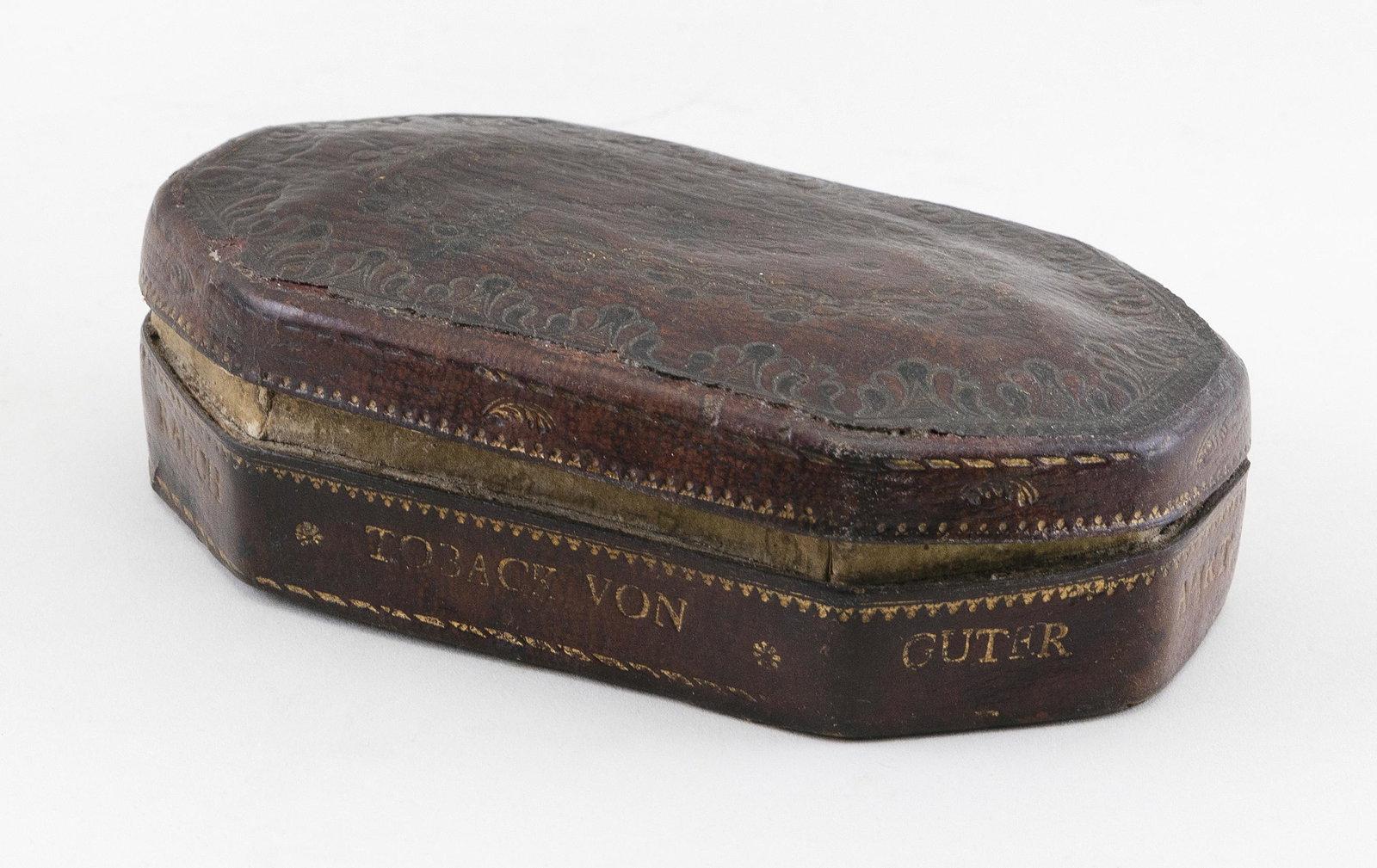 GERMAN LEATHER TOBACCO BOX Circa 1745 Length 5”.: GERMAN LEATHER TOBACCO BOX Circa 1745 Octagonal, with hinged cover. Exterior tooled and gilded with foliage and the motto “Ver Wahrt der Rauch Toback von Guter Ahrt Wird in Meine Dose”. Co