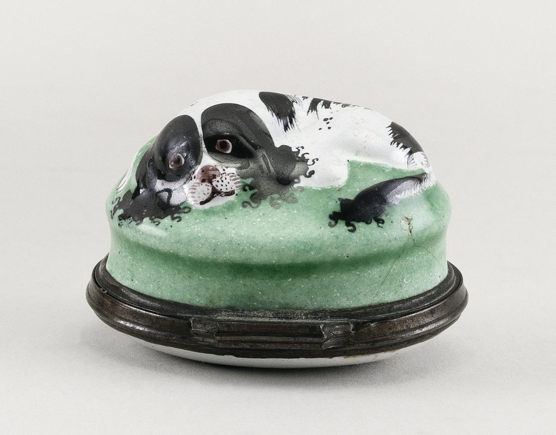 ENGLISH ENAMEL SPANIEL BONBONNIERE Circa 1770 Length 1.75".: ENGLISH ENAMEL SPANIEL BONBONNIERE Circa 1770 Black and white recumbent dog on a green cushion. Cover painted with a flower spray. Length 1.75".