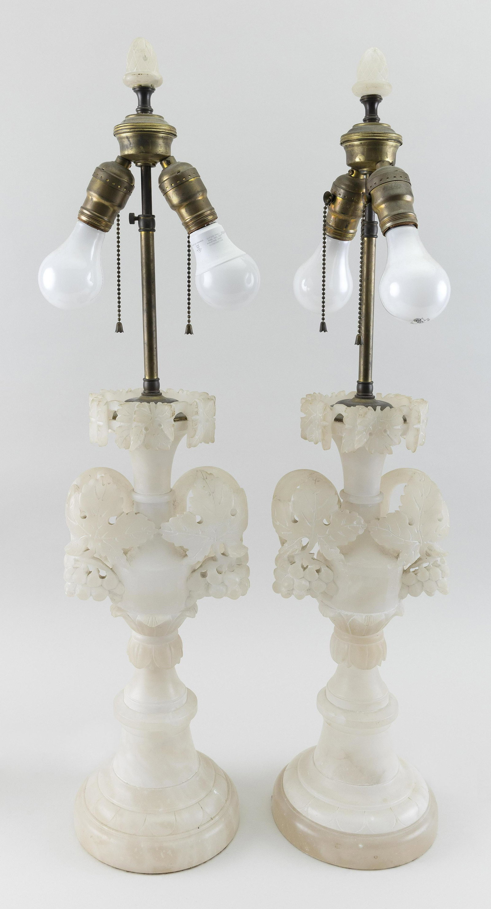 PAIR OF ALABASTER TABLE LAMPS 20th Century Heights 31”.: PAIR OF ALABASTER TABLE LAMPS 20th Century Carved with grapes and leaves. Heights 31”.