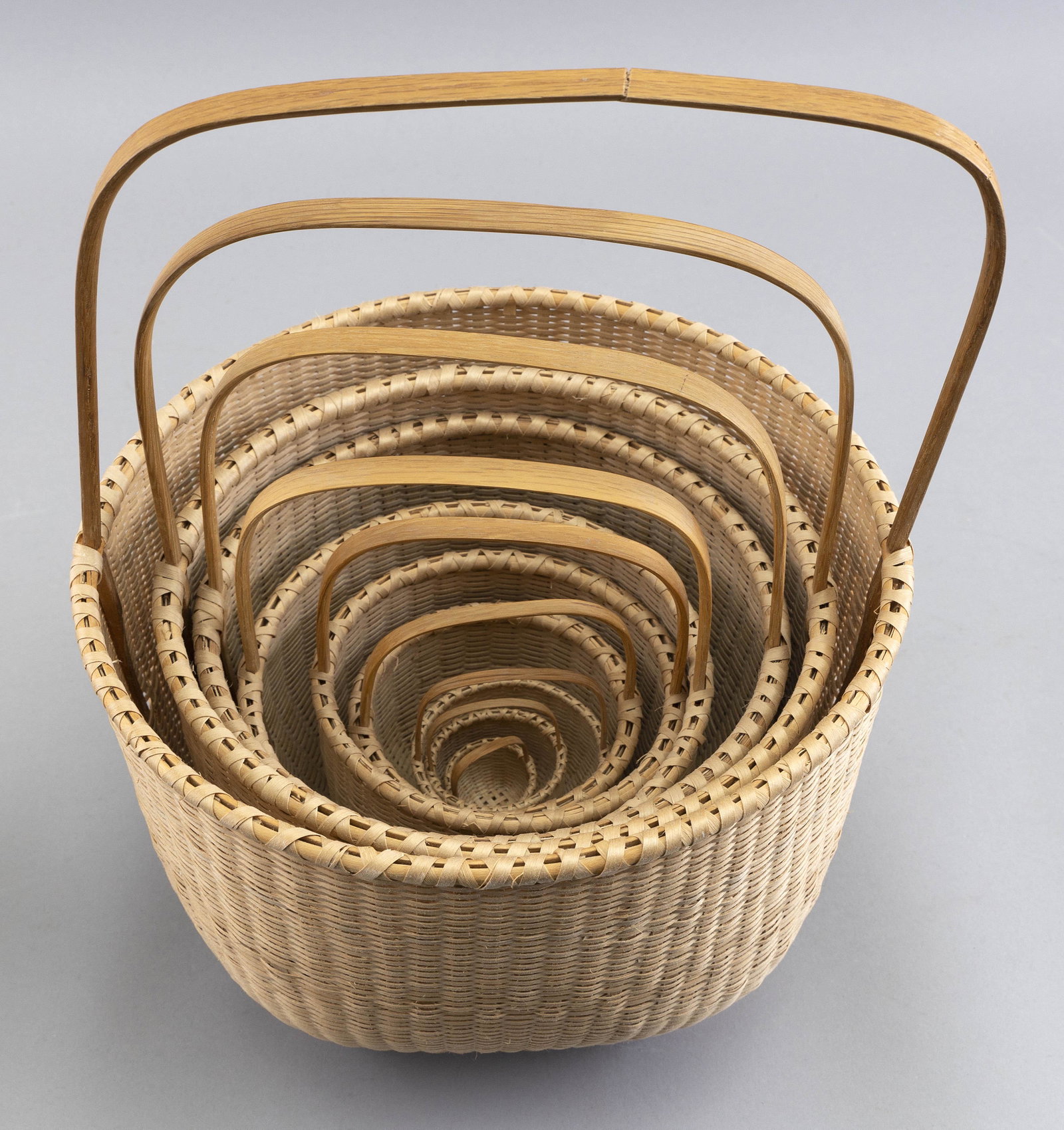 NESTING SET OF NINE HANDWOVEN BASKETS BY JOAN CASHIN Contemporary Diameters from 1.25” to: NESTING SET OF NINE HANDWOVEN BASKETS BY JOAN CASHIN Contemporary Most with monogram signature; some dated. Diameters from 1.25” to 9.75”.
