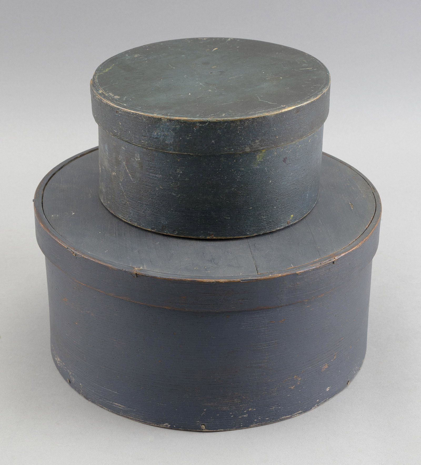 TWO ROUND FINGER-LAPPED WOODEN BOXES New England, Late 19th Century: TWO ROUND FINGER-LAPPED WOODEN BOXES New England, Late 19th Century One painted dark green, height 3.5” and diameter 6.5”, and the other in painted blue, height 4.75” and diameter 9.