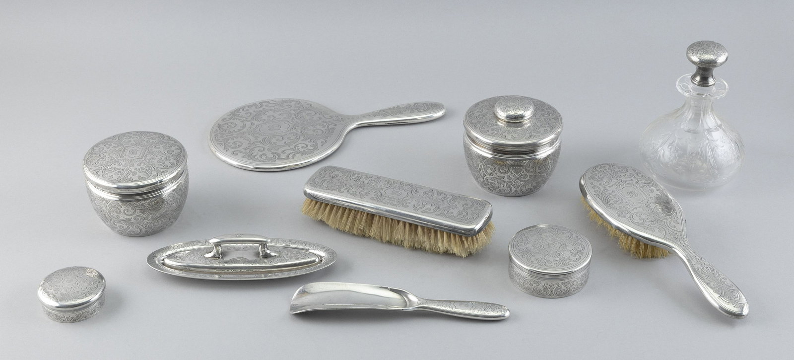 TIFFANY & CO. STERLING SILVER TEN-PEICE DRESSER SET New York, Early 20th Century Approx. 27.8 troy: TIFFANY & CO. STERLING SILVER TEN-PEICE DRESSER SET New York, Early 20th Century Two brushes, a hand mirror, a glass perfume bottle, four covered jars, a lint brush with undertray and a shoe horn. App