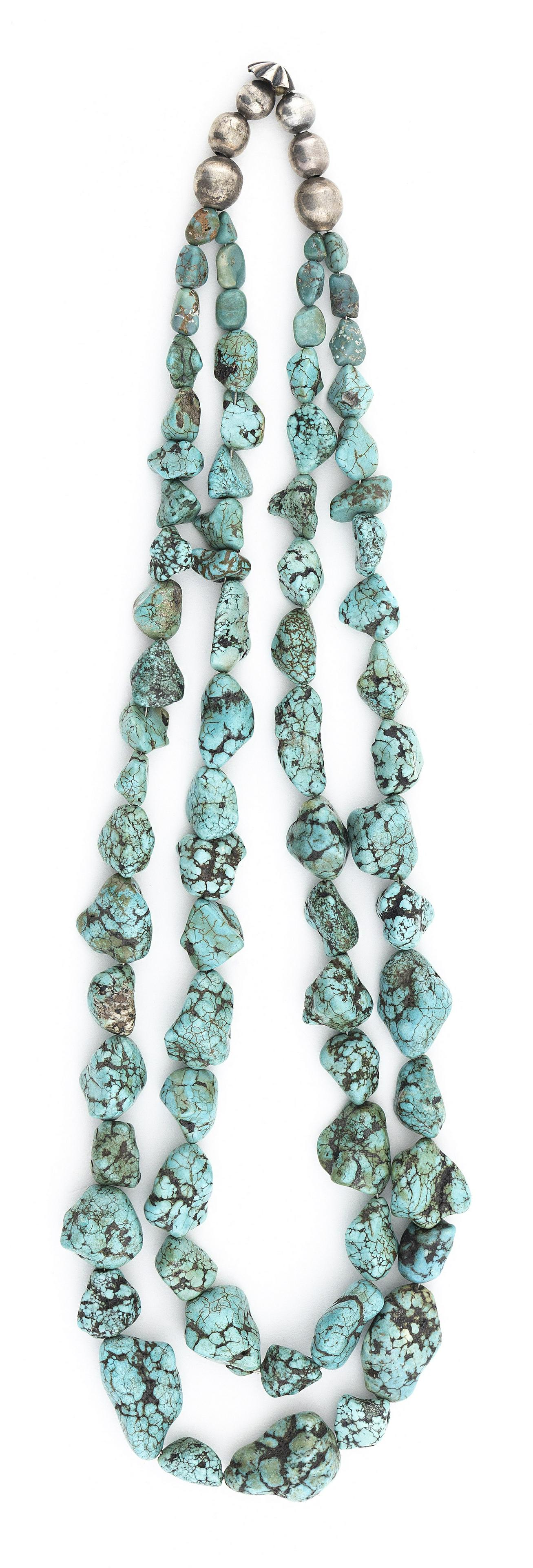NAVAJO CANDELARIA TURQUOISE NECKLACE Mid-20th Century Approx. 250 total grams: NAVAJO CANDELARIA TURQUOISE NECKLACE Mid-20th Century Two strands of graduated Candelaria turquoise nuggets measuring up to approx. 1”. Ends with handmade silver beads and a rosette. Length 27&#