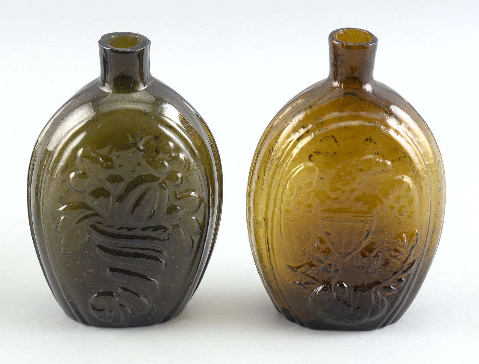 TWO AMERICAN HISTORICAL GLASS FLASKS 19th Century: TWO AMERICAN HISTORICAL GLASS FLASKS 19th Century 1) GII-73 in medium brown. Height 6.75”. 2) GIII-4 in olive green. Height 6.75”.