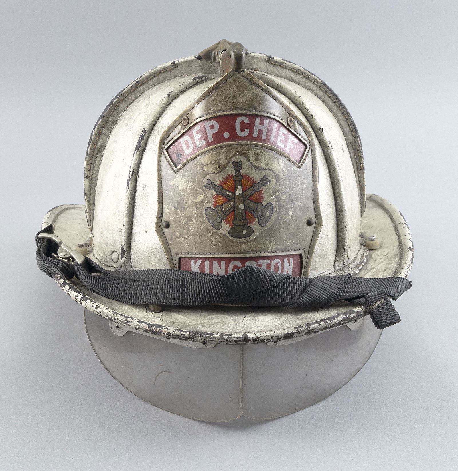 KINGSTON FIRE DEPARTMENT LEATHER HELMET 20th Century Length 15”.: KINGSTON FIRE DEPARTMENT LEATHER HELMET20th CenturyWhite helmet. "Dep. Chief Kingston" shield at front.Length 15”.