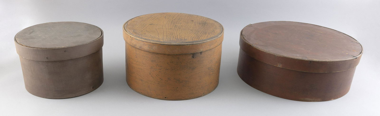 THREE LIDDED DRY MEASURES New England, 19th Century: THREE LIDDED DRY MEASURESNew England, 19th CenturyOne painted brown, height 6” and diameter 9.5”, one painted orange, height 6.75” and diameter 11.75”, and one painted red, hei