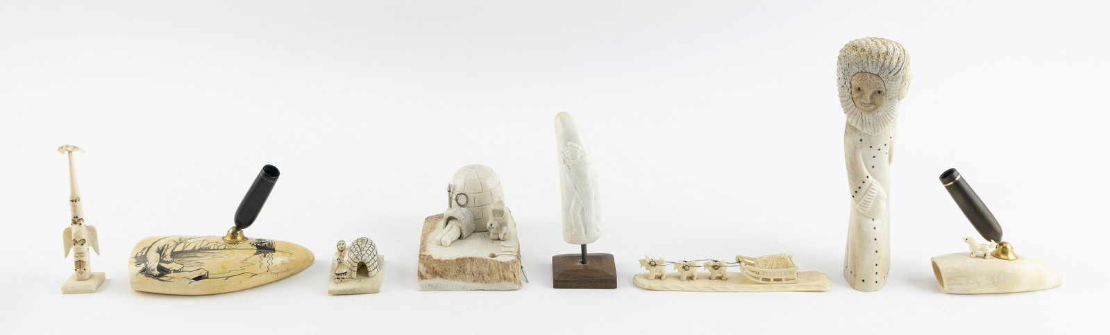 EIGHT ESKIMO IVORY AND BONE ITEMS 20th Century Heights to 7.75".: EIGHT ESKIMO IVORY AND BONE ITEMS 20th Century Includes two pen holders with whale's-tooth bases, one engraved with a polar bear and the other a relief-carved tusk. Also includes two igloos, a double-