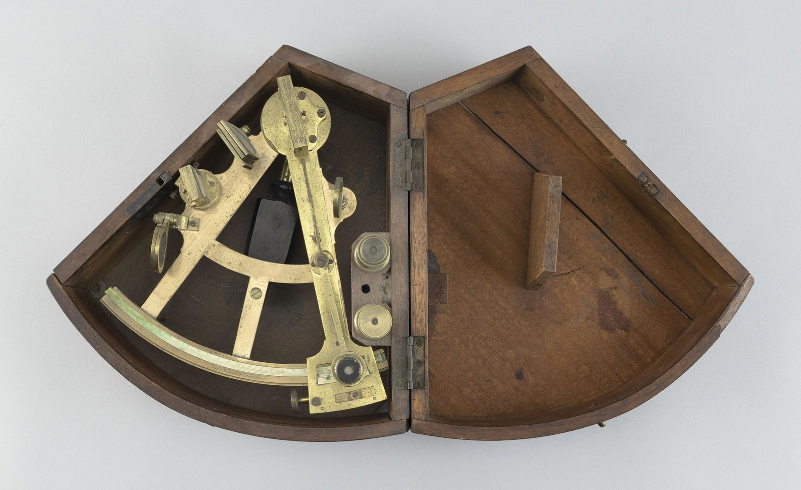 CASED BRASS OCTANT 19th Century Case height 5.75”. Length 11.25”. Width 11.25”.: CASED BRASS OCTANT 19th Century Signed “Louis Casartellis Liverpool”. Includes two lenses. Wedge-shaped mahogany case. Case height 5.75”. Length 11.25”. Width 11.25”.