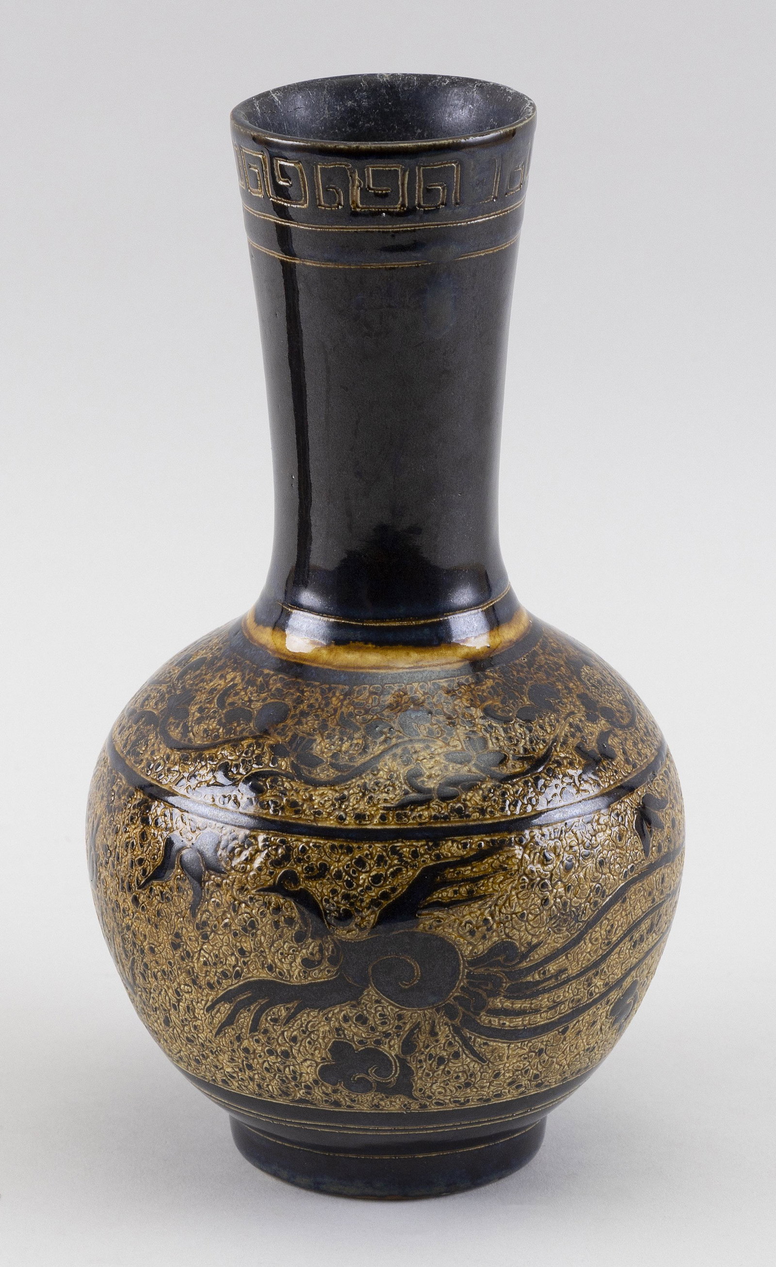 CHINESE SGRAFFITO POTTERY BOTTLE VASE Late 19th Century Height 9.5”.: CHINESE SGRAFFITO POTTERY BOTTLE VASE Late 19th Century Body decorated with a dragon chasing a fiery pearl on a mottled brown ground over a dark blue glaze. Height 9.5”.