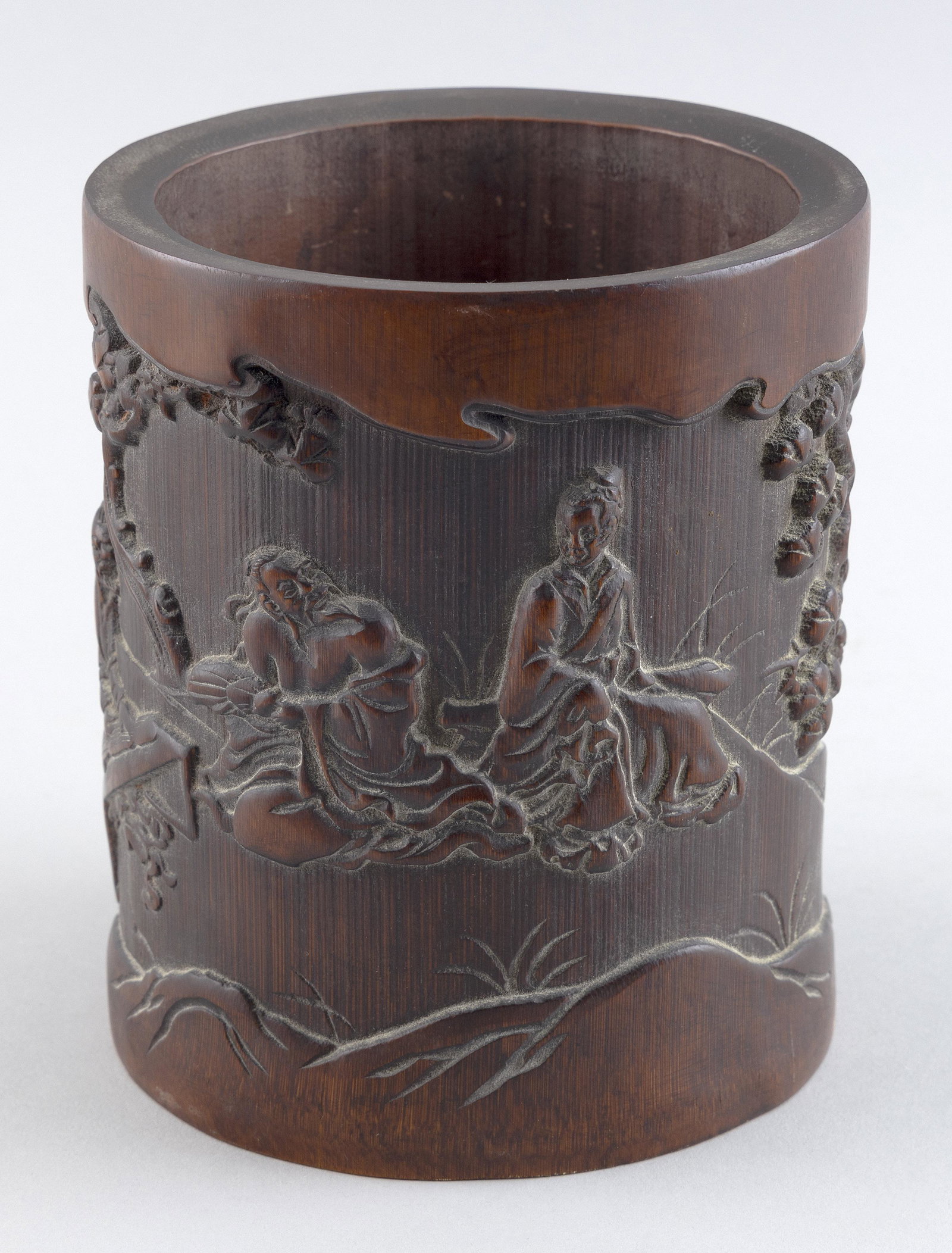 CHINESE CARVED BAMBOO BRUSH POT Late 19th/Early 20th Century Height 6.5”. Diameter of top: CHINESE CARVED BAMBOO BRUSH POT Late 19th/Early 20th Century Figural landscape decoration. Height 6.5”. Diameter of top 5”.