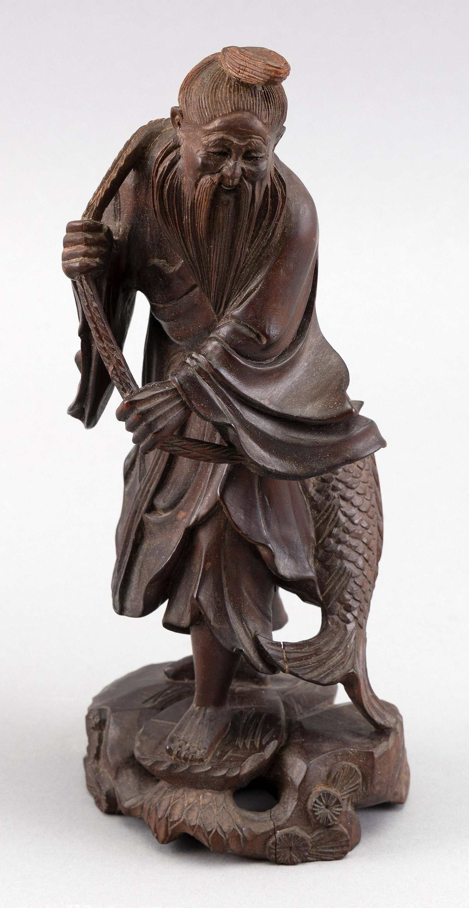 JAPANESE CARVED WOOD FIGURE OF EBISU Meiji Period Height 8".: JAPANESE CARVED WOOD FIGURE OF EBISU Meiji Period Standing on rockery and carrying a large carp with an inlaid eye over his shoulder. Height 8".