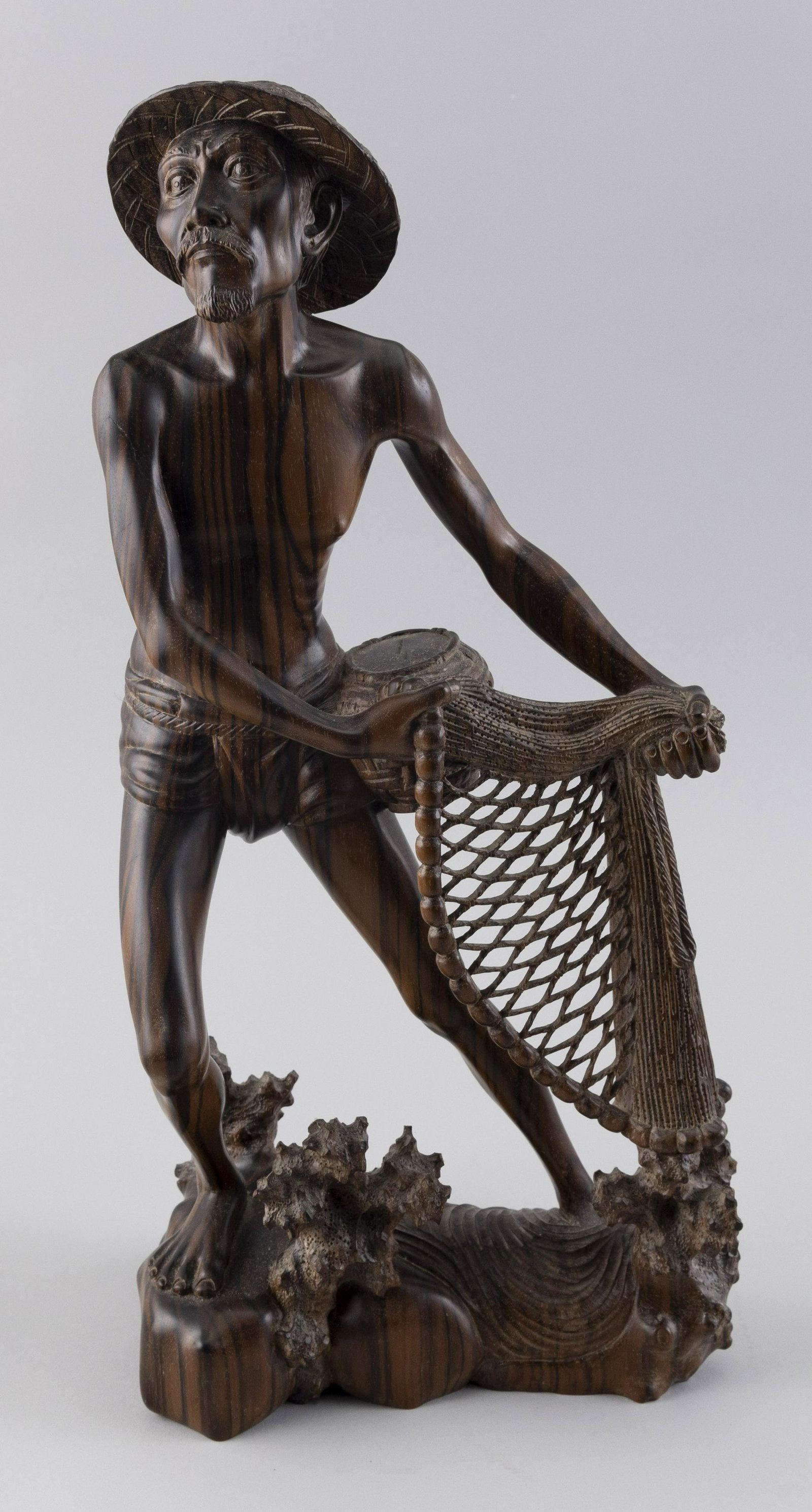 CARVED WOODEN FIGURE OF A BALINESE NATIVE FISHERMAN 20th Century Height 17.75”.: CARVED WOODEN FIGURE OF A BALINESE NATIVE FISHERMAN 20th Century Marked on bottom “Niana Tilem Gallery Mas Bali”. Height 17.75”.