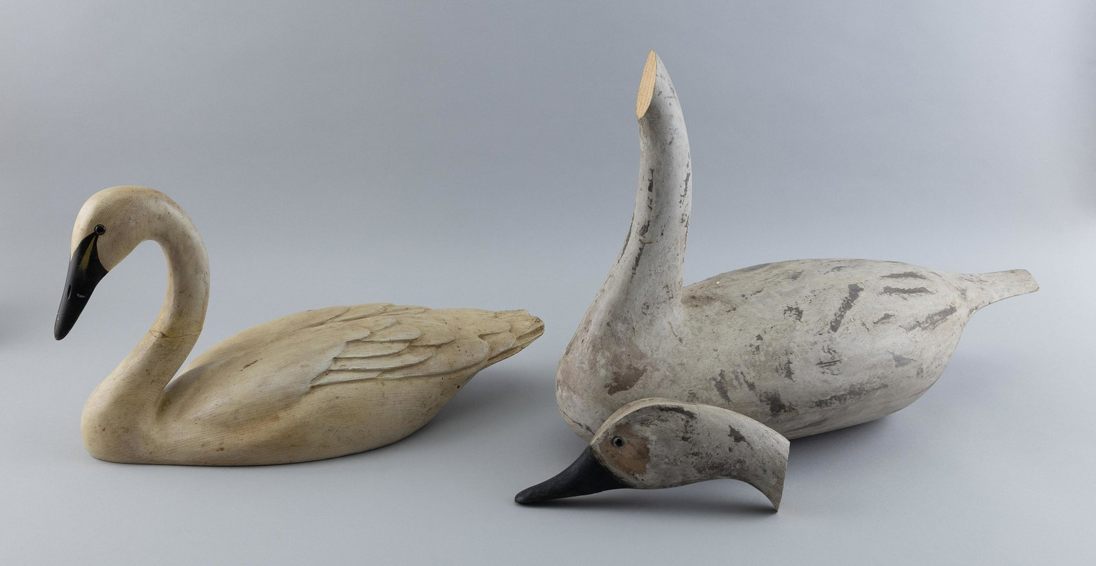 TWO CARVED WOODEN SWANS 20th Century Lengths 18” and 23”.: TWO CARVED WOODEN SWANS 20th Century One from Pennsylvania and one by Bob Hayden. Lengths 18” and 23”.
