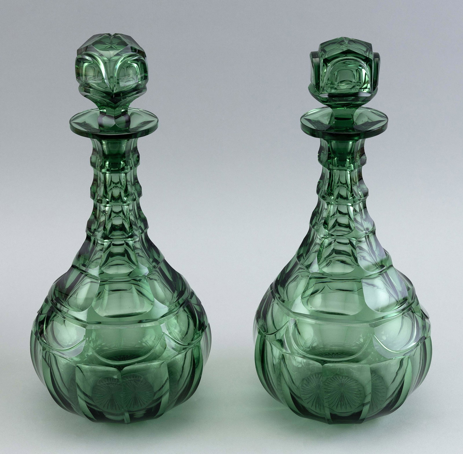 PAIR OF ENGLISH CUT GREEN GLASS DECANTERS 19th Century Heights 12”.: PAIR OF ENGLISH CUT GREEN GLASS DECANTERS 19th Century With globe stoppers and tapered necks. Heights 12”.