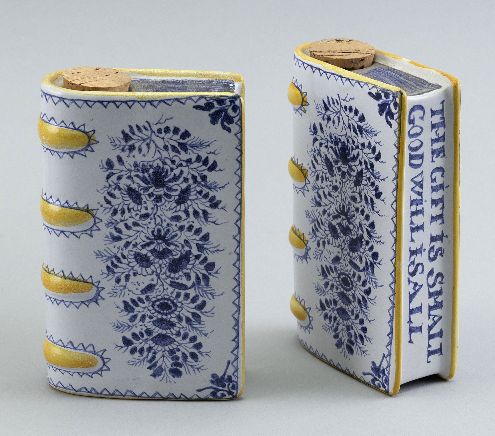 PAIR OF DELFT-STYLE BOOK-FORM FLASKS Contemporary Heights 5.25”. Widths 3.75”.: PAIR OF DELFT-STYLE BOOK-FORM FLASKSContemporaryMetropolitan Museum of Art reproductions. “The Gift is Small The Will is All” on the page-side edges.Heights 5.25”. Widths 3.75”