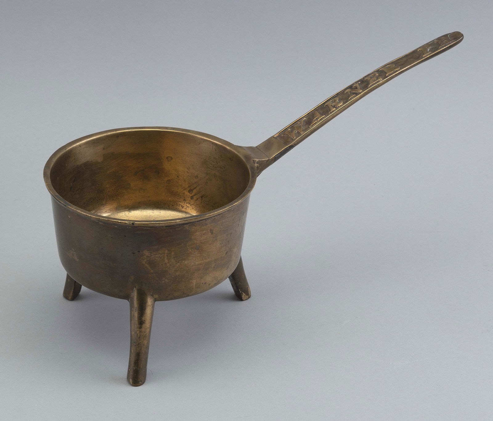 BELL METAL POSNET England, 18th Century Pot height 4.75”. Diameter 5.75”. Total length: BELL METAL POSNETEngland, 18th CenturyHandle molded “Warner PH”.Pot height 4.75”. Diameter 5.75”. Total length 12”. Provenance:William Dixon Collection.Notes: