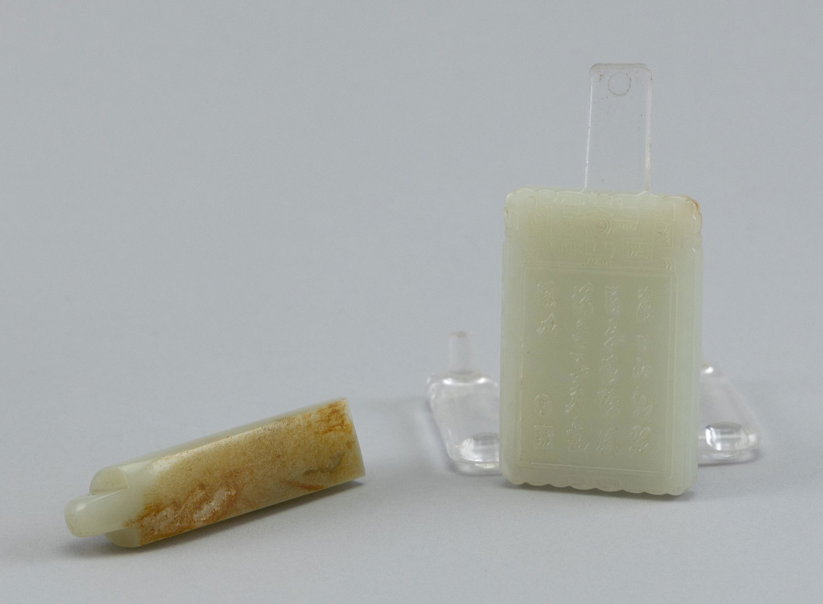 TWO CHINESE CARVED LIGHT CELADON PENDANTS Lengths 2.5" and 2.75". (1 of 2)