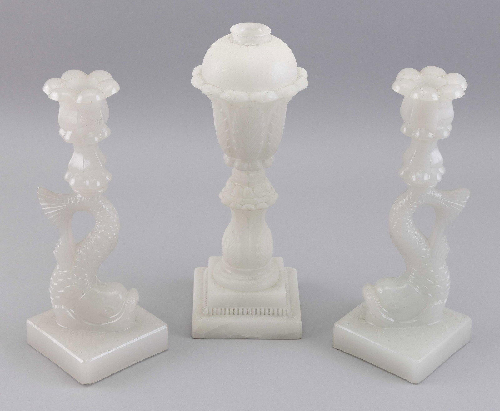 THREE PIECES OF SANDWICH GLASS 19th Century: THREE PIECES OF SANDWICH GLASS 19th Century 1-2) Pair of dolphin candlesticks in clambroth. Heights 10.25Ã®. 3) Acanthus leaf whale oil lamp in opaque white with sand finish. Height 11.25Ã®.