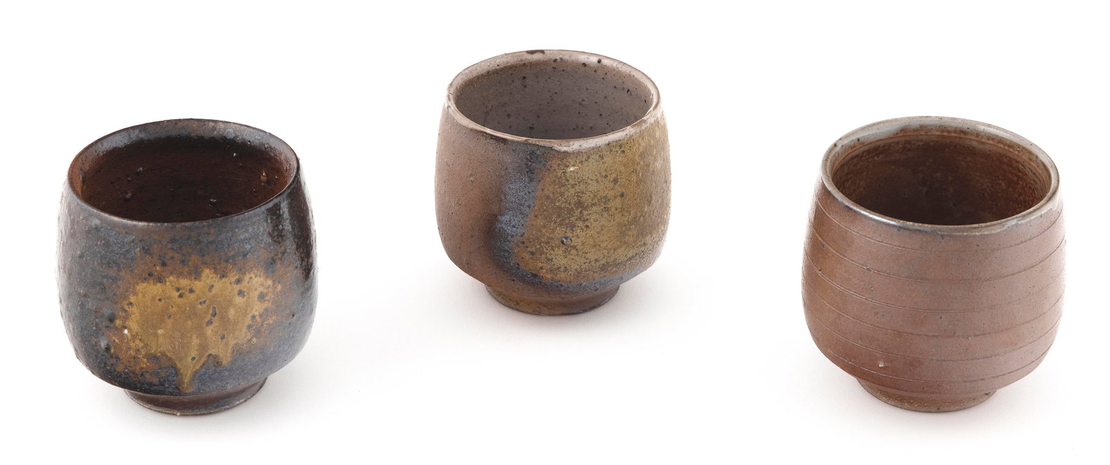 JUN ISEZAKI (Japan, 1936-), Three Bizen pottery tea bowls in various ash glazes., Heights approx. 3. (1 of 3)