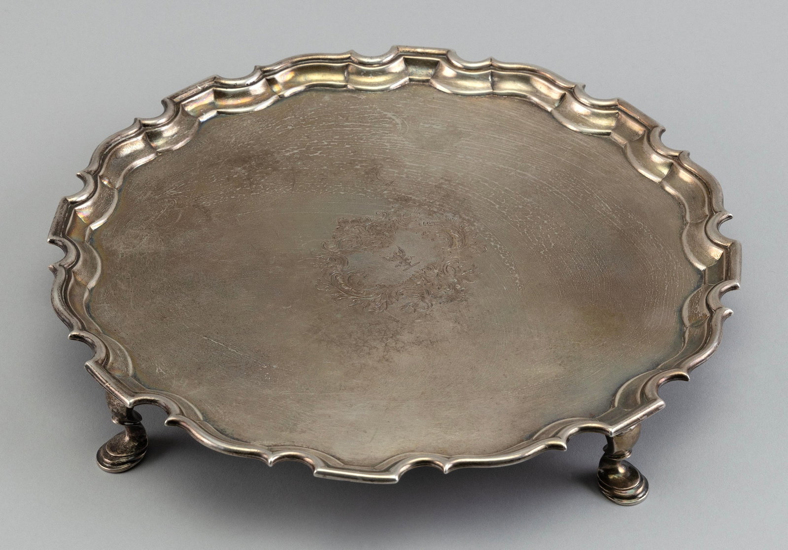 ENGLISH STERLING SILVER SALVER London, Early 19th Century Approx. 24.6 troy oz.: ENGLISH STERLING SILVER SALVER London, Early 19th Century Chippendale-style with central engraving of a winged griffin surrounded by sprays of flowers. Raised on four feet. Hallmarks for London, 1812,
