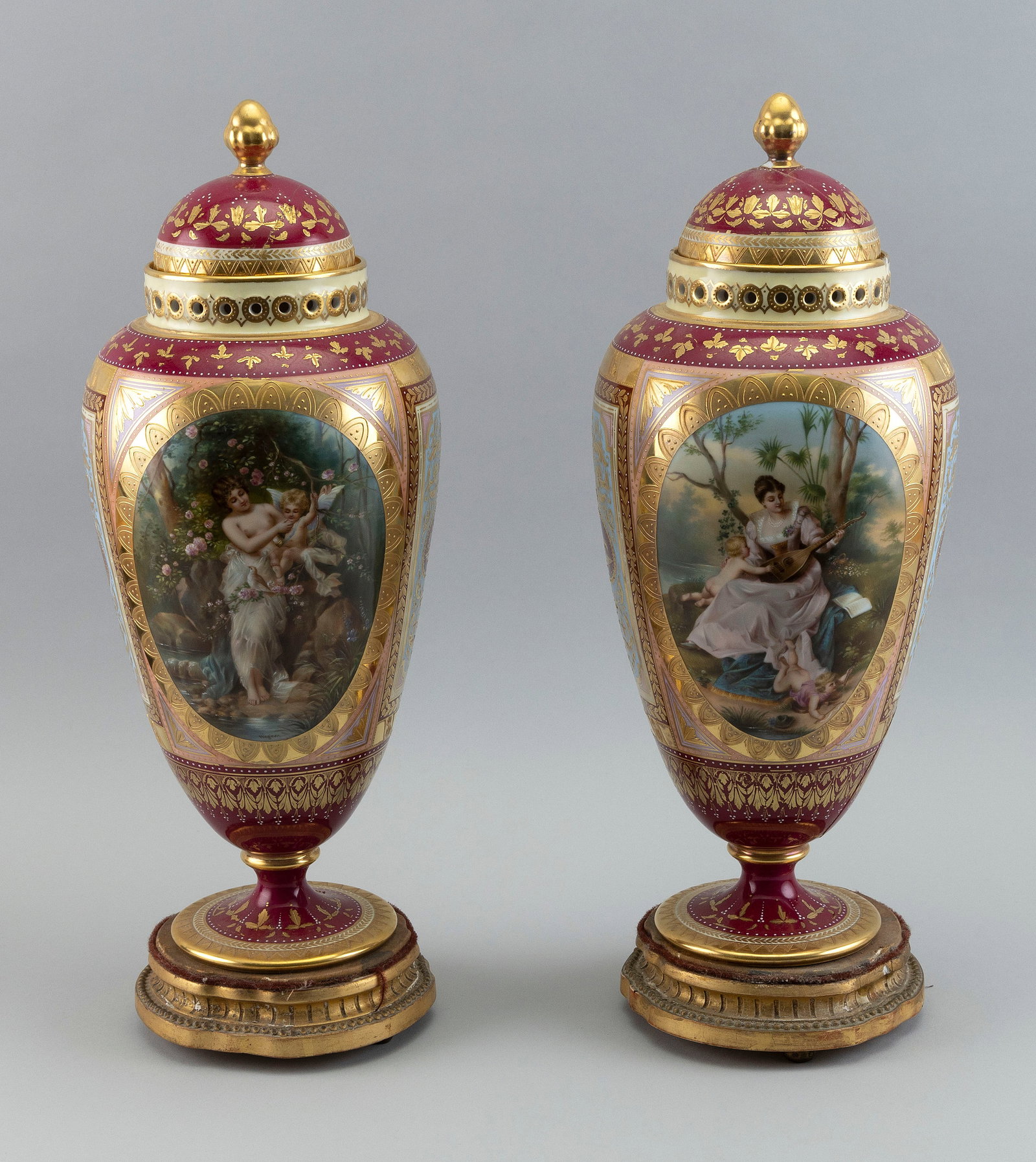 PAIR OF ACKERMANN & FRITZE PORCELAIN VASES Germany, Early 20th Century Heights 16î.: PAIR OF ACKERMANN & FRITZE PORCELAIN VASES Germany, Early 20th Century With gilt decoration and painted figural scenes signed Wagner. Includes gilt-decorated wooden bases. Heights 16Ã®.