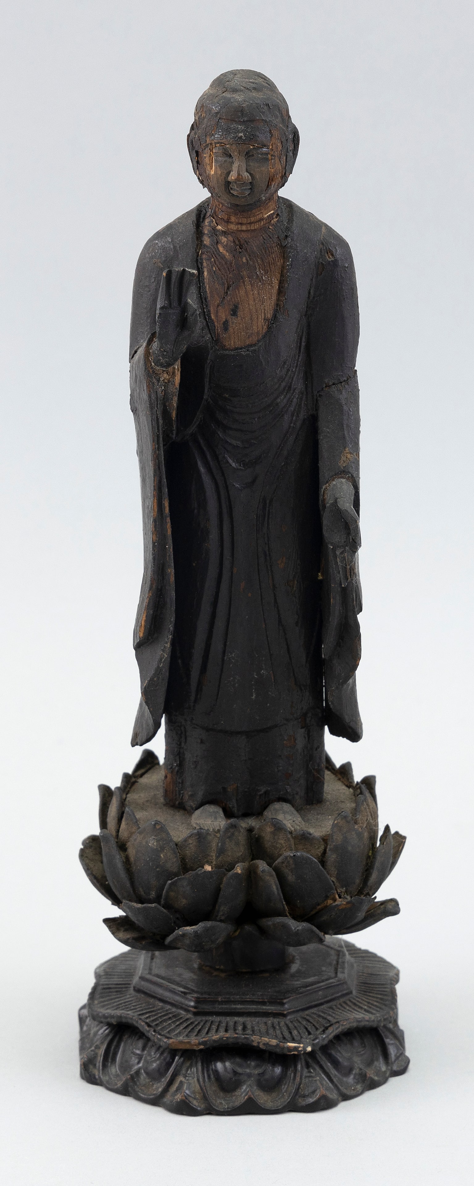 JAPANESE CARVED WOOD BUDDHA 18th/19th Century Height 10".: JAPANESE CARVED WOOD BUDDHA 18th/19th Century In flowering robes and standing on a lotus base. Missing flame mandala and shrine. Height 10".