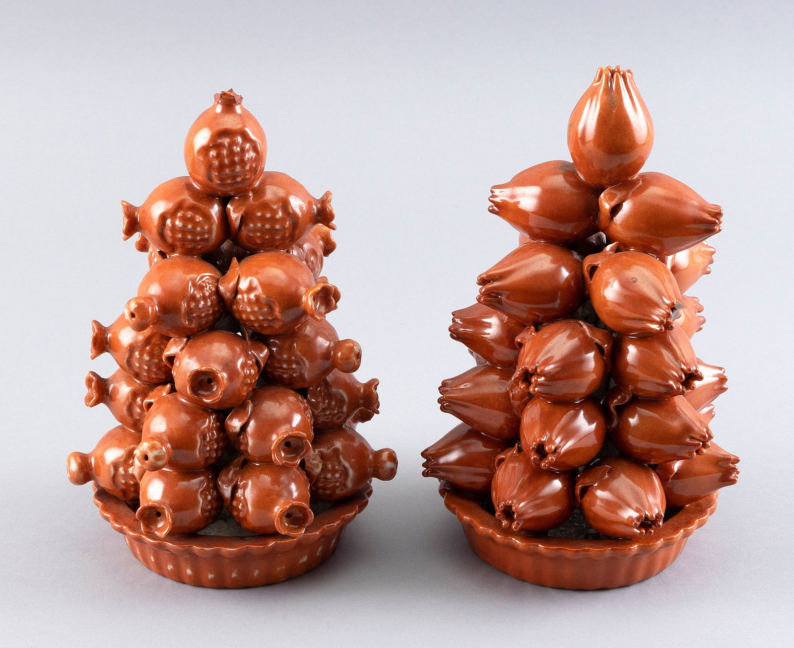 NEAR-PAIR OF CHINESE CORAL GLAZE PORCELAIN ALTAR FRUIT PYRAMIDS 19th Century Heights 8.5".: NEAR-PAIR OF CHINESE CORAL GLAZE PORCELAIN ALTAR FRUIT PYRAMIDS 19th Century Shallow fluted baskets, one filled with pomegranates and the other with citrons. Heights 8.5". Notes: For a similar example