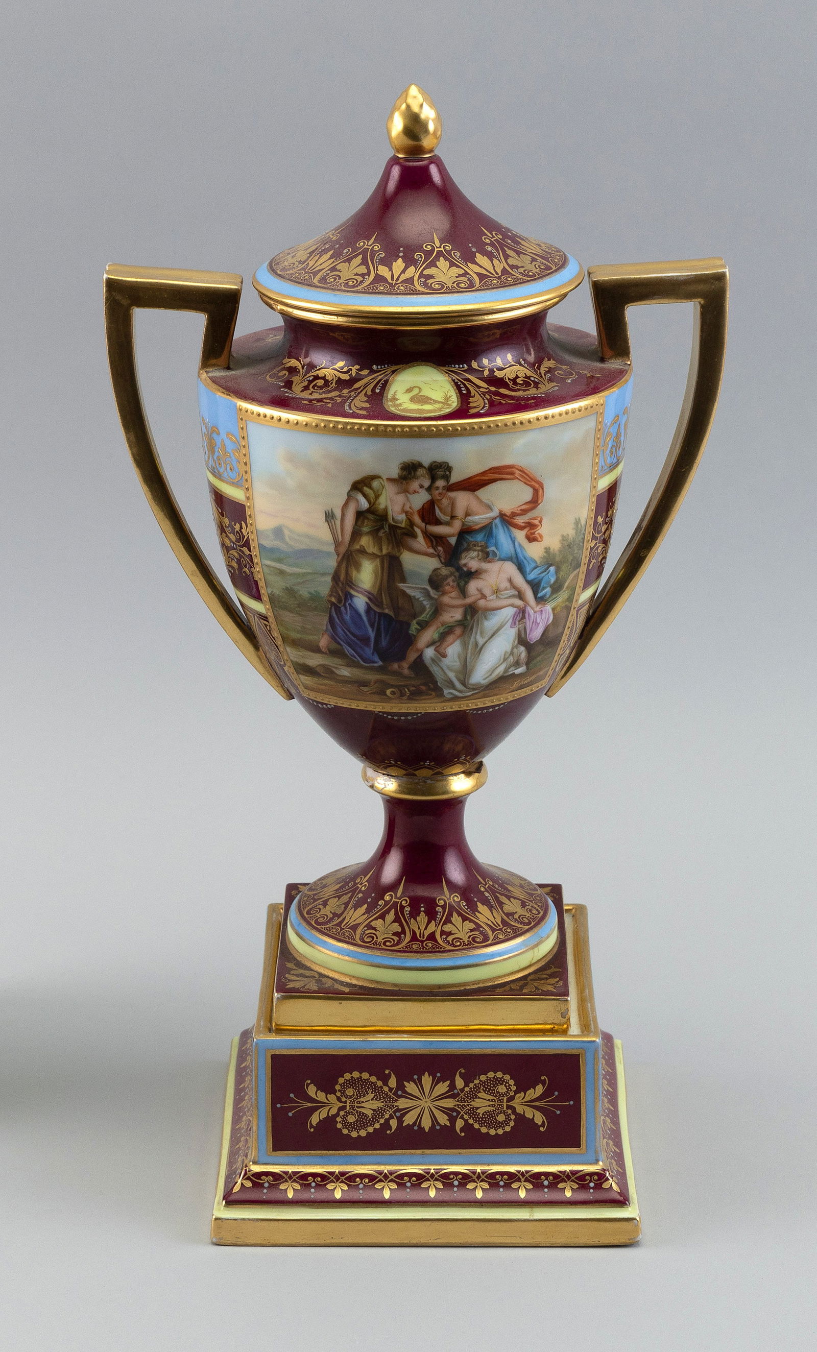 ACKERMANN & FRITZE PORCELAIN COVERED URN Germany, Late 19th Century Height 14".: ACKERMANN & FRITZE PORCELAIN COVERED URNGermany, Late 19th CenturyWith gilt decoration and a painted scene of classical figures. On matching base.Height 14".