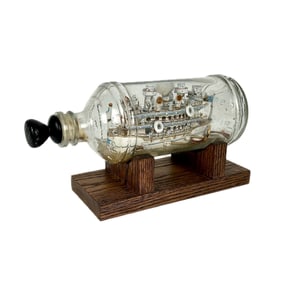 FOLK ART SHIP-IN-A-BOTTLE Late 20th Century Height on stand 5.5". Length 9.5".