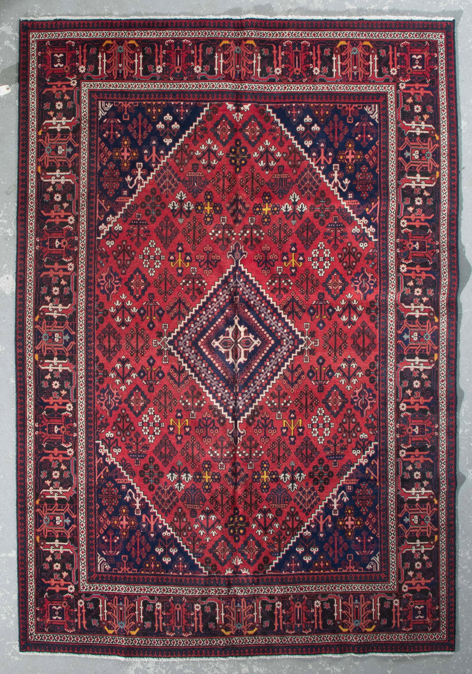 JOSHEGHAN RUG: 7í3" X 10í6" Second Half of the 20th Century: JOSHEGHAN RUG: 7í3" X 10í6" Second Half of the 20th Century Rich red field features a blue central medallion and traditional diamond-shaped clusters of bright ivory, yellow and other jewel-t