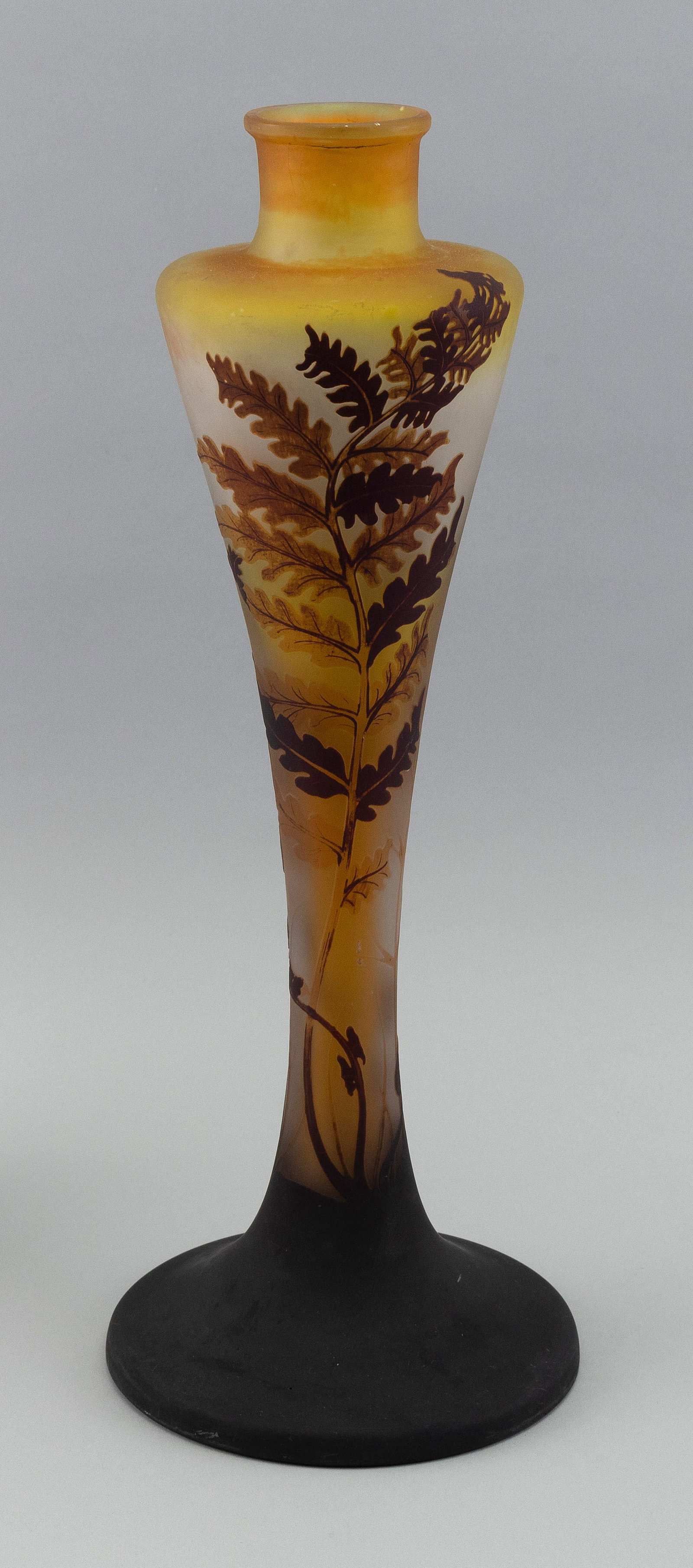 GALL… CAMEO GLASS VASE France, Early 20th Century Height 16.5". Base diameter 6.5".: GALL… CAMEO GLASS VASE France, Early 20th Century Fiddlehead design in golden yellow and browns against a white and amber ground. Signed "GallÈ" in cameo. Old labels on base. Height 16.5". Base dia