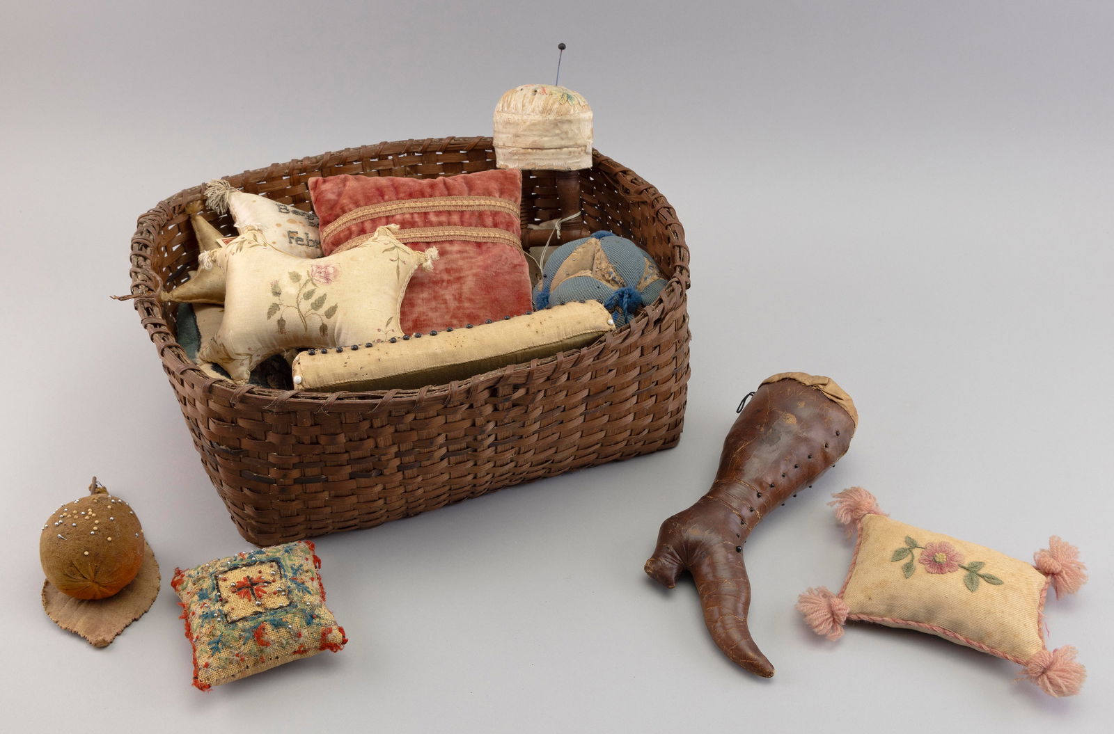 SPLINT BASKET FILLED WITH SEWING IMPLEMENTS Late 18th to Early 20th Century Basket length 16.5". (1 of 2)