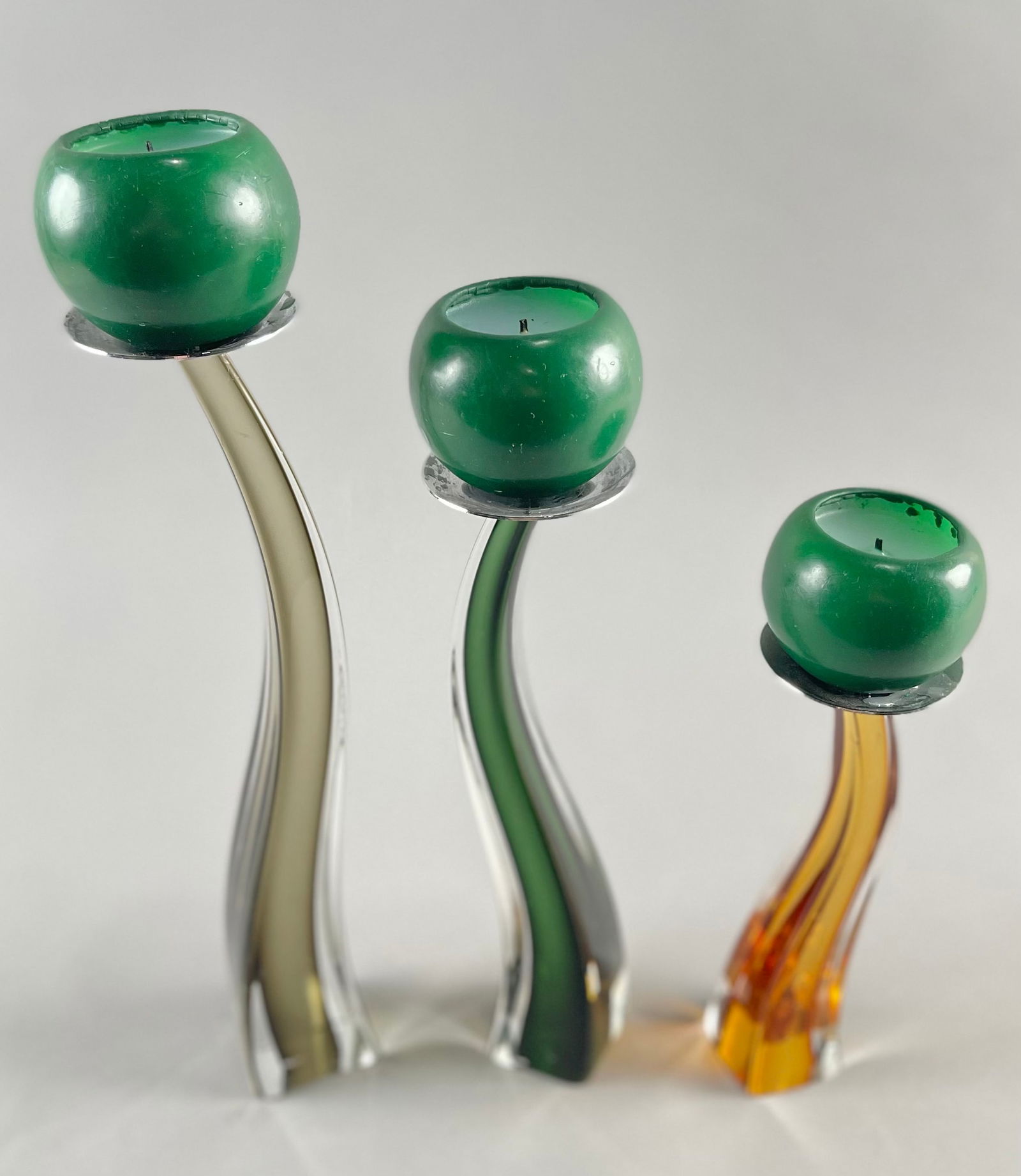 THREE GIULIANO TOSI MURANO GLASS CANDLESTICKS Italy, Circa 1980s Heights from 8" to 12.75".: THREE GIULIANO TOSI MURANO GLASS CANDLESTICKSItaly, Circa 1980sGray, green and orange. Signed on undersides "Studio Tosi".Heights from 8" to 12.75".