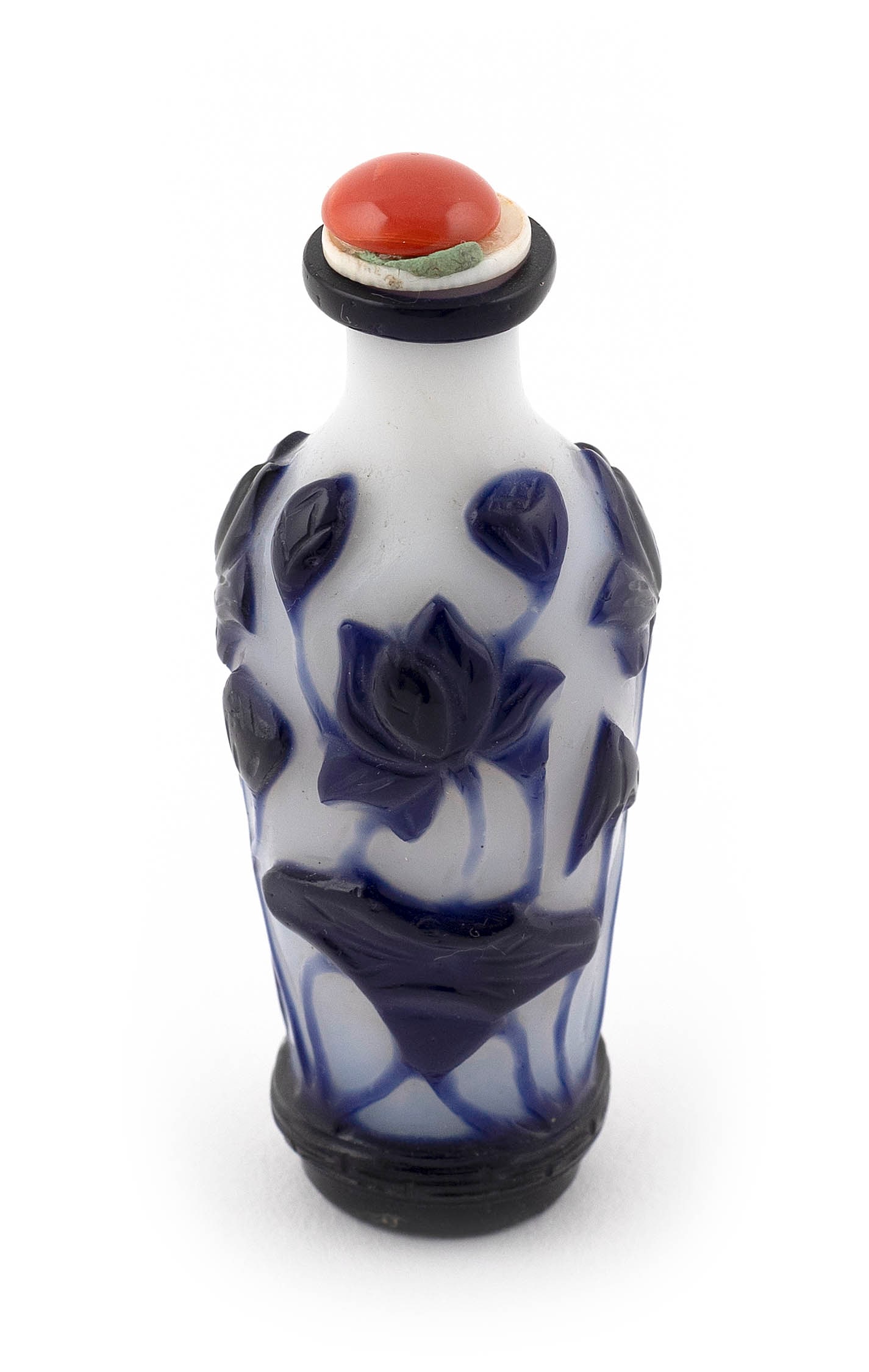 CHINESE COBALT CUT TO CLEAR OVERLAY GLASS SNUFF BOTTLE Late 19th Century Height 3". Red stone: CHINESE COBALT CUT TO CLEAR OVERLAY GLASS SNUFF BOTTLELate 19th CenturySlender baluster form. Decoration of lotus stems.Height 3". Red stone stopper.