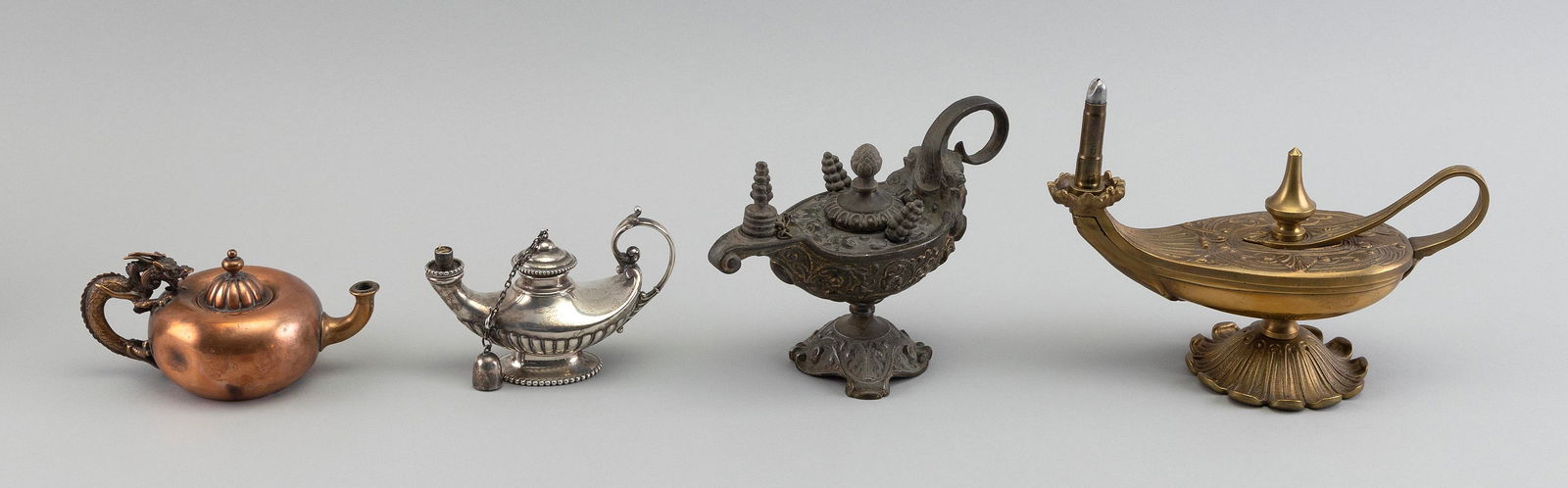 FOUR ALADDIN-STYLE METAL LAMPS Early 20th Century Heights from 2.25" to 5.5". (1 of 1)