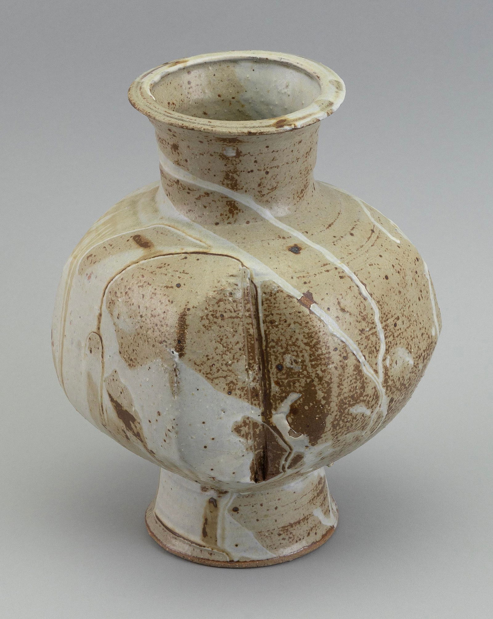 MAKOTO YABE (Japan/Massachusetts, 1947-2005), Stoneware globular vase with pinched sides., Height: MAKOTO YABEJapan/Massachusetts, 1947-2005Stoneware globular vase with pinched sides. Earth tone and white drip glaze. Signed on underside.Height 10".