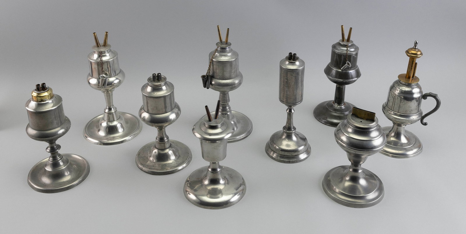 NINE AMERICAN PEWTER LAMPS, MOSTLY WHALE OIL Mid-19th Century Heights from 7" to 8.25".: NINE AMERICAN PEWTER LAMPS, MOSTLY WHALE OIL Mid-19th Century In varied forms. One marked "Capen & Molineux NY". Heights from 7" to 8.25".