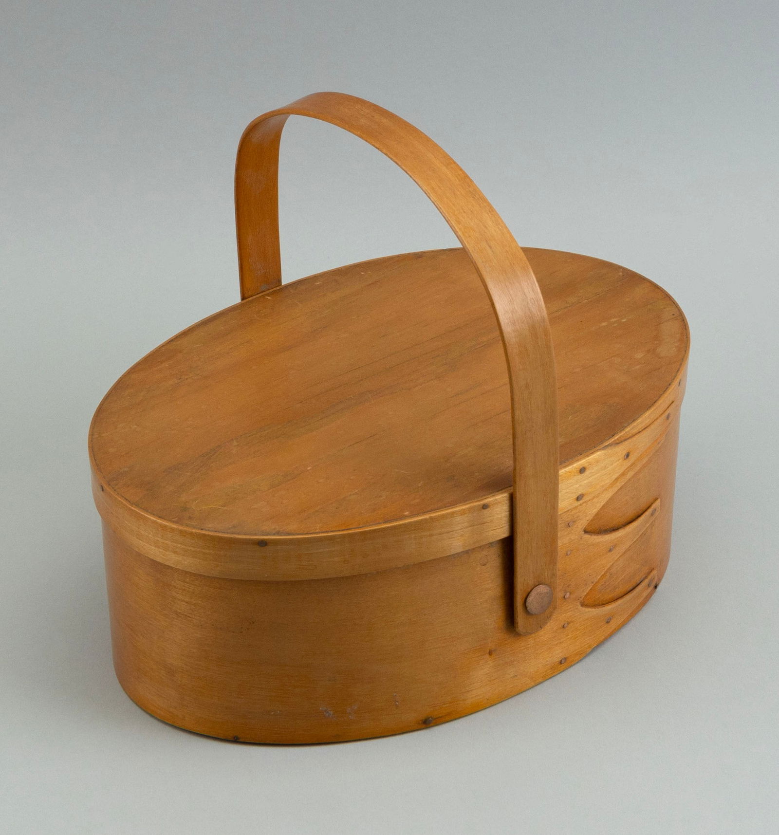 SHAKER SEWING BASKET Late 19th/Early 20th Century Height to rim 3.5". Length 9.5". Width 6.5".: SHAKER SEWING BASKETLate 19th/Early 20th CenturyWith swing handle. Interior with pin cushions and a basketweave needle case.Height to rim 3.5". Length 9.5". Width 6.5". Provenance:An Upstate New York