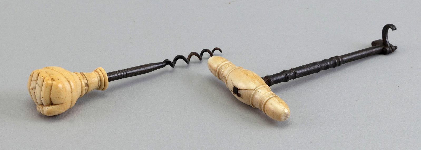TWO WHALE IVORY-HANDLED TOOLS 19th Century Lengths 6" and 6.5".: TWO WHALE IVORY-HANDLED TOOLS 19th Century One handle carved as a beefy fist clenching a snake, the snake with a spade-shaped tongue and a fat body that wraps around the fist. Other handle, the instru