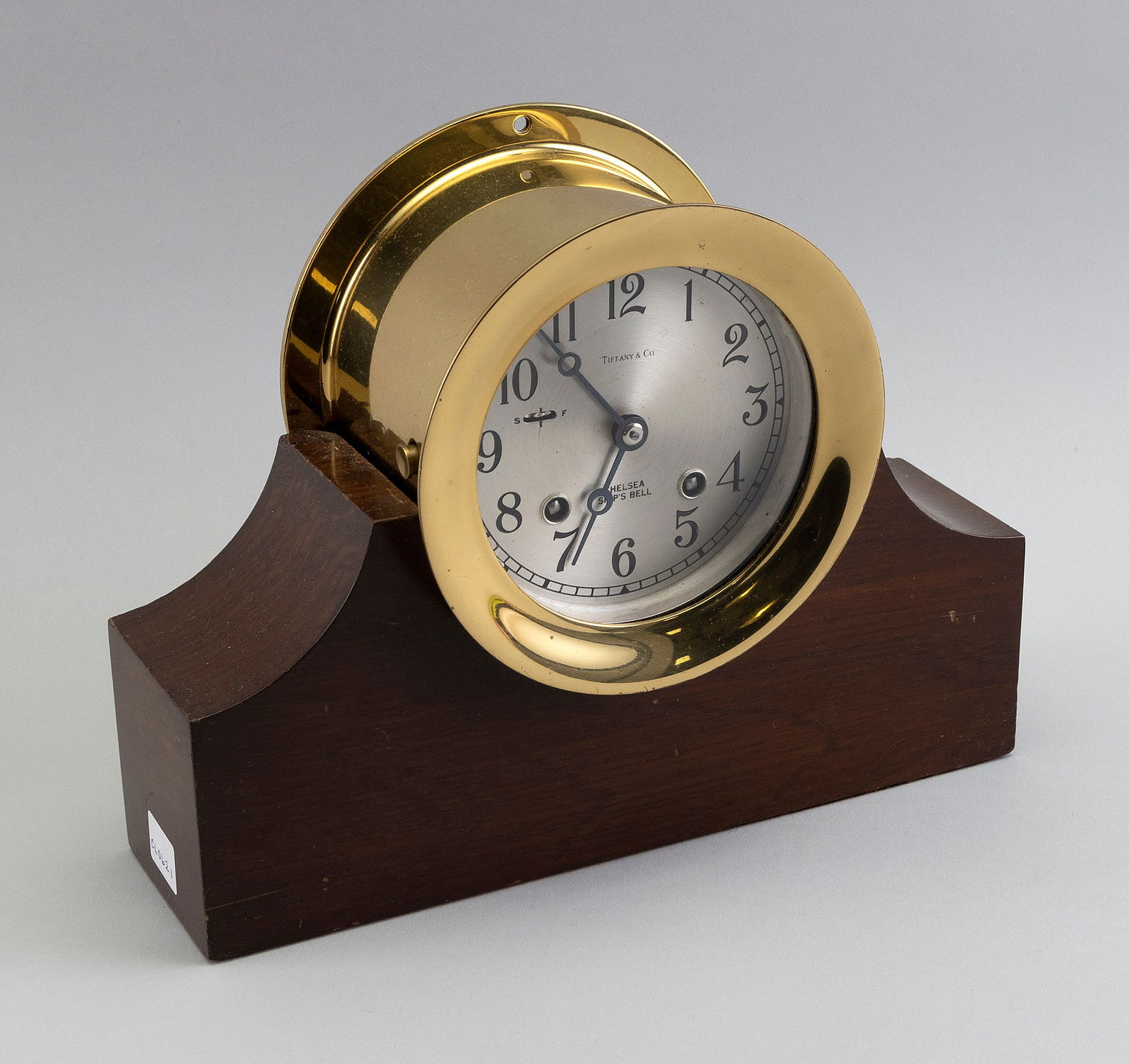 TIFFANY & CO. CHELSEA SHIP'S BELL CLOCK ON STAND Boston, 20th Century Height 7.75". Dial diameter: TIFFANY & CO. CHELSEA SHIP'S BELL CLOCK ON STANDBoston, 20th CenturySerial #799180. Brass case. Hinged bezel with push-button release. Silvered Arabic numeral dial marked "Tiffany & Co" and "Chelsea S
