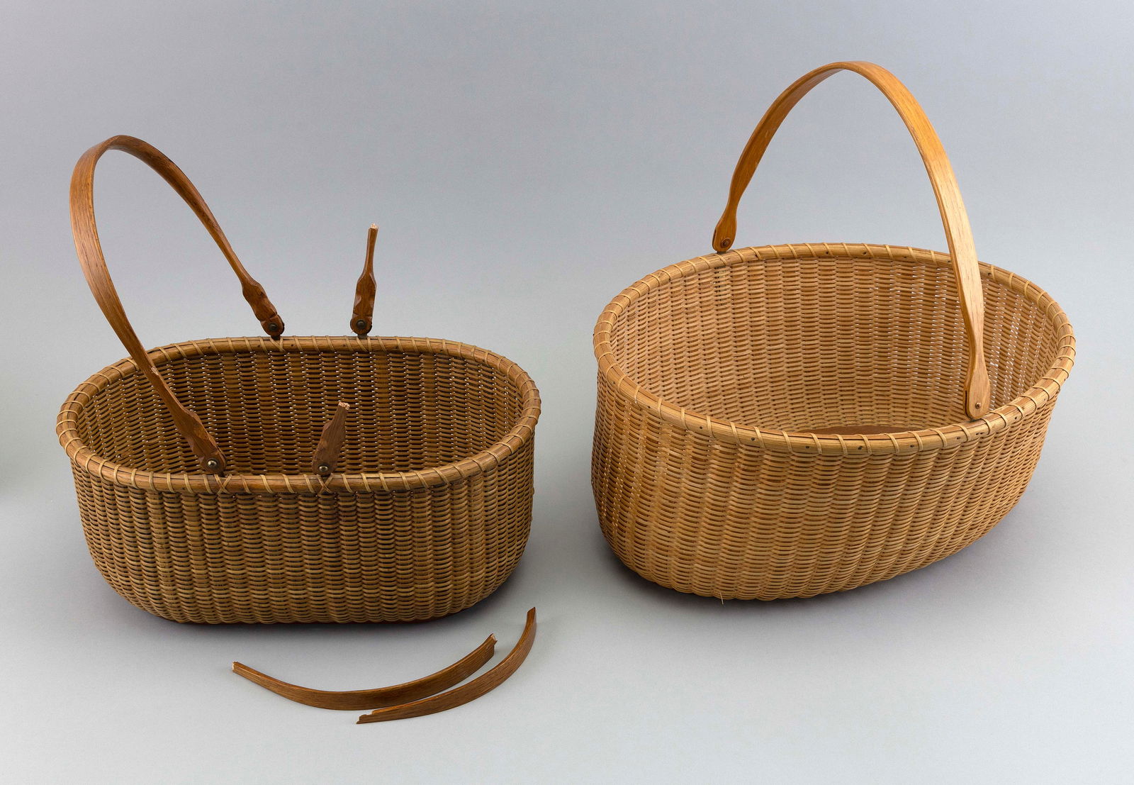TWO NANTUCKET-STYLE BASKETS Contemporary Heights to rim 5.5” and 6.25”.: TWO NANTUCKET-STYLE BASKETSContemporaryBoth oval. One signed and dated “Rosenquist 1985” and the other “Harry Hilbert”.Heights to rim 5.5” and 6.25”.