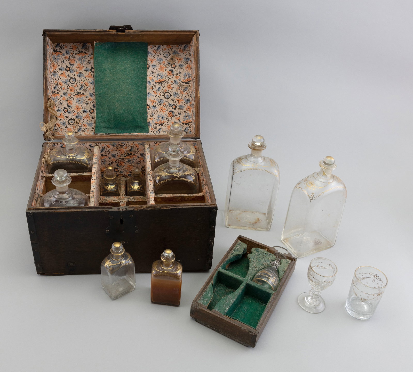 SHIP'S LIQUOR SET 19th Century Case height 10". Width 15". Depth 10".: SHIP'S LIQUOR SET 19th Century Paper-lined fitted interior contains six large and six small gilt-decorated liquor bottles, two stemmed glasses and a cordial. Case height 10". Width 15". Depth 10".