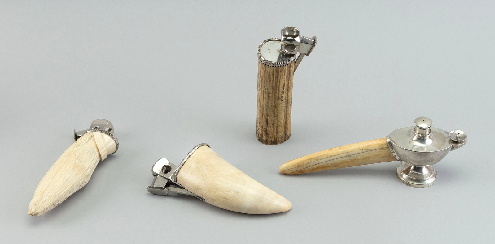 THREE WHALE'S TOOTH CIGAR CUTTERS AND A LIGHTER Early 20th Century Lengths from 6" to 8.5".: THREE WHALE'S TOOTH CIGAR CUTTERS AND A LIGHTER Early 20th Century Aladdin's lamp-form lighter with petrified walrus tusk handle. Lengths from 6" to 8.5".