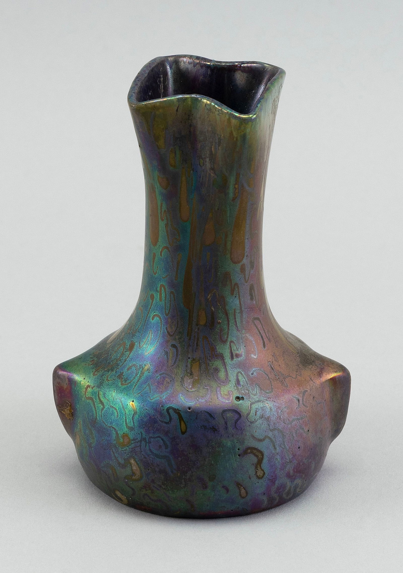 JEROME MASSIER FILS IRIDESCENT EARTHENWARE VASE France, Late 19th/Early 20th Century Height 4.5".: JEROME MASSIER FILS IRIDESCENT EARTHENWARE VASEFrance, Late 19th/Early 20th CenturyPinched neck and pointed body. Iridescent green, purple, red and gold "squiggle" glaze. Signed on base "J Massier Fil